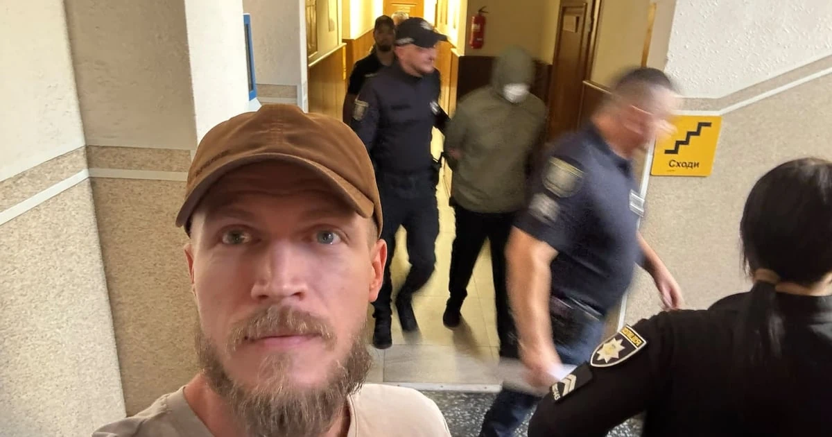 Олександр Ширшин на тлі того, як одного з підозрюваних виводять із зали суду, 11 вересня 2026 року